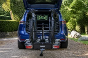 Porte-vélos pliable et basculant transportant deux vélos électriques à l’arrière d’un véhicule, coffre accessible