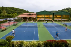 Club de tennis Charly accueillant, avec adultes et enfants jouant sur plusieurs courts extérieurs et couverts.